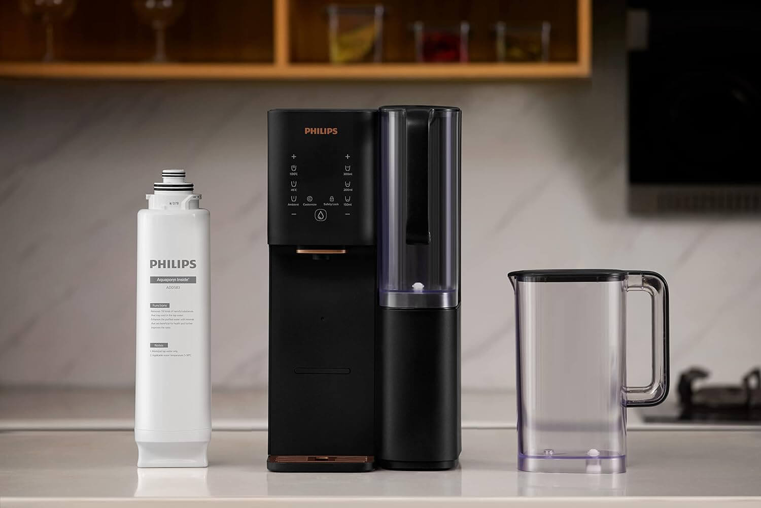 A black Philips Aquaporin Inside Reverse Osmosis Filter ADD583/79 (2000L) system, featuring a a white cartridge on the left and a transparent jug, positioned on a kitchen counter.