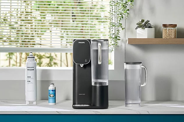 Philips hot and chilled water station on a countertop between the ADD541 and coconut shell replacement filters and a glass water pitcher.