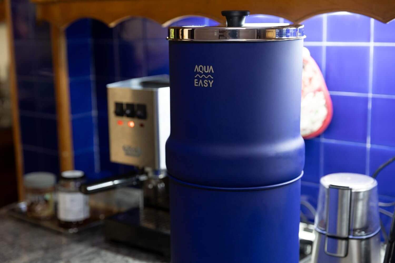 A blue AquaEasy Stainless Steel Gravity Water Filter System featuring a stainless steel lid and black knob.