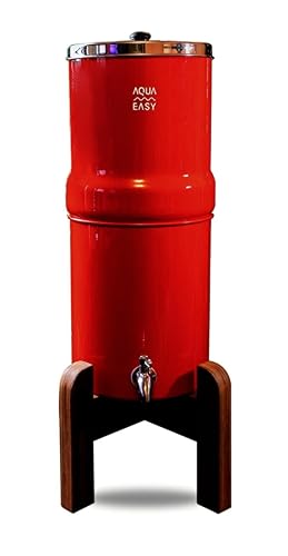A red AquaEasy Gravity Water Filter System sits on a wooden stand, stainless steel lid and spigot.