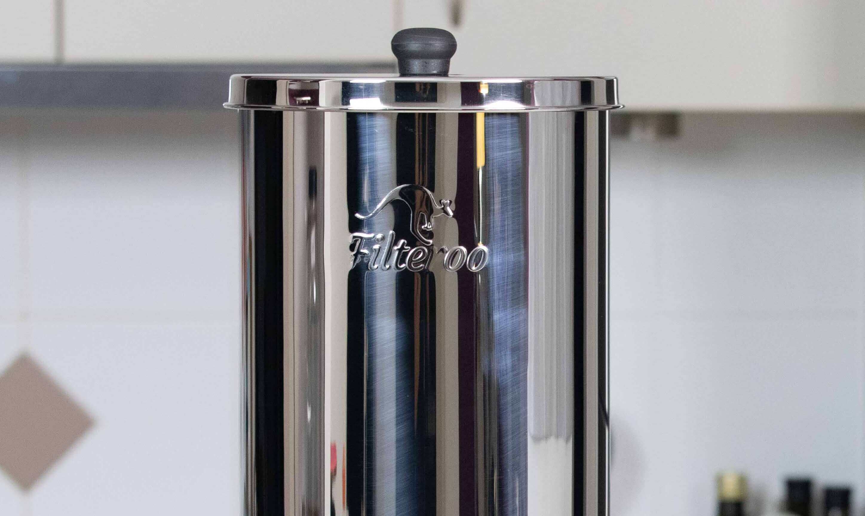 Filteroo® Superoo stainless steel gravity water filter featuring black lid knob, showcased in a kitchen setting.