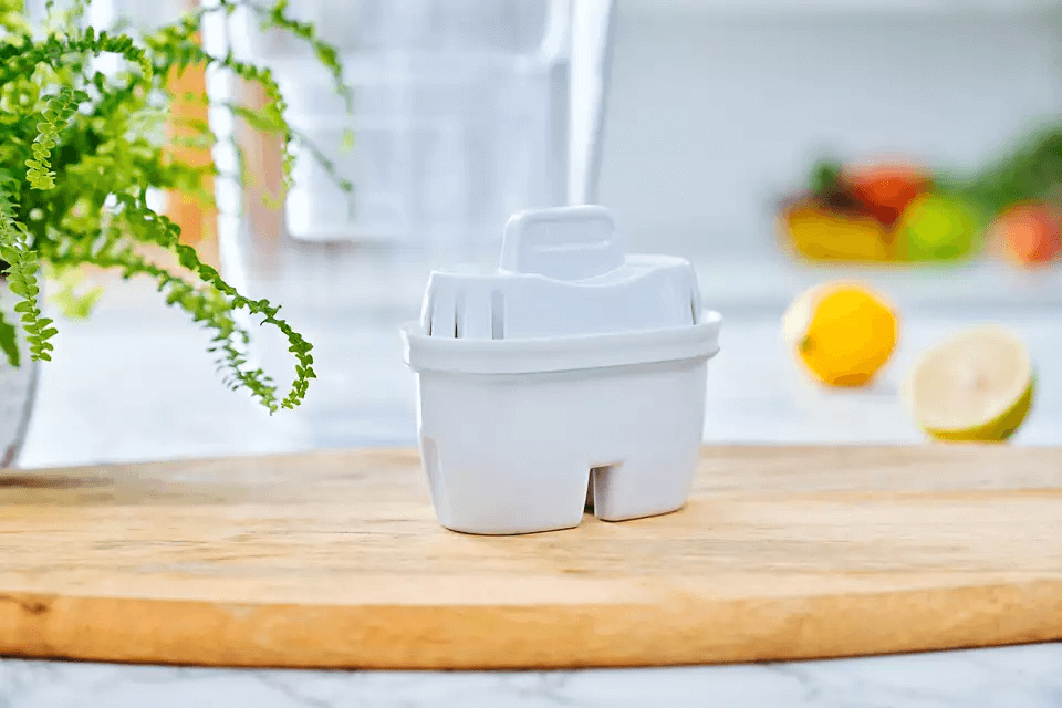 Philips Micro X-Clean Carbon Filter on a wooden board with fruits and a plant in the background.
