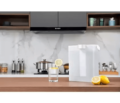 Philips Micro X-Clean Filter AWP225/79 pitcher in white with a glass of water and  a lemon slice on a kitchen counter.