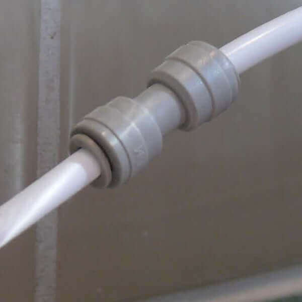 Close-up of a gray pipe connector joining two white pipes in the 3 Stage Portable Reverse Osmosis Water Filter System with Alkalising Filter.