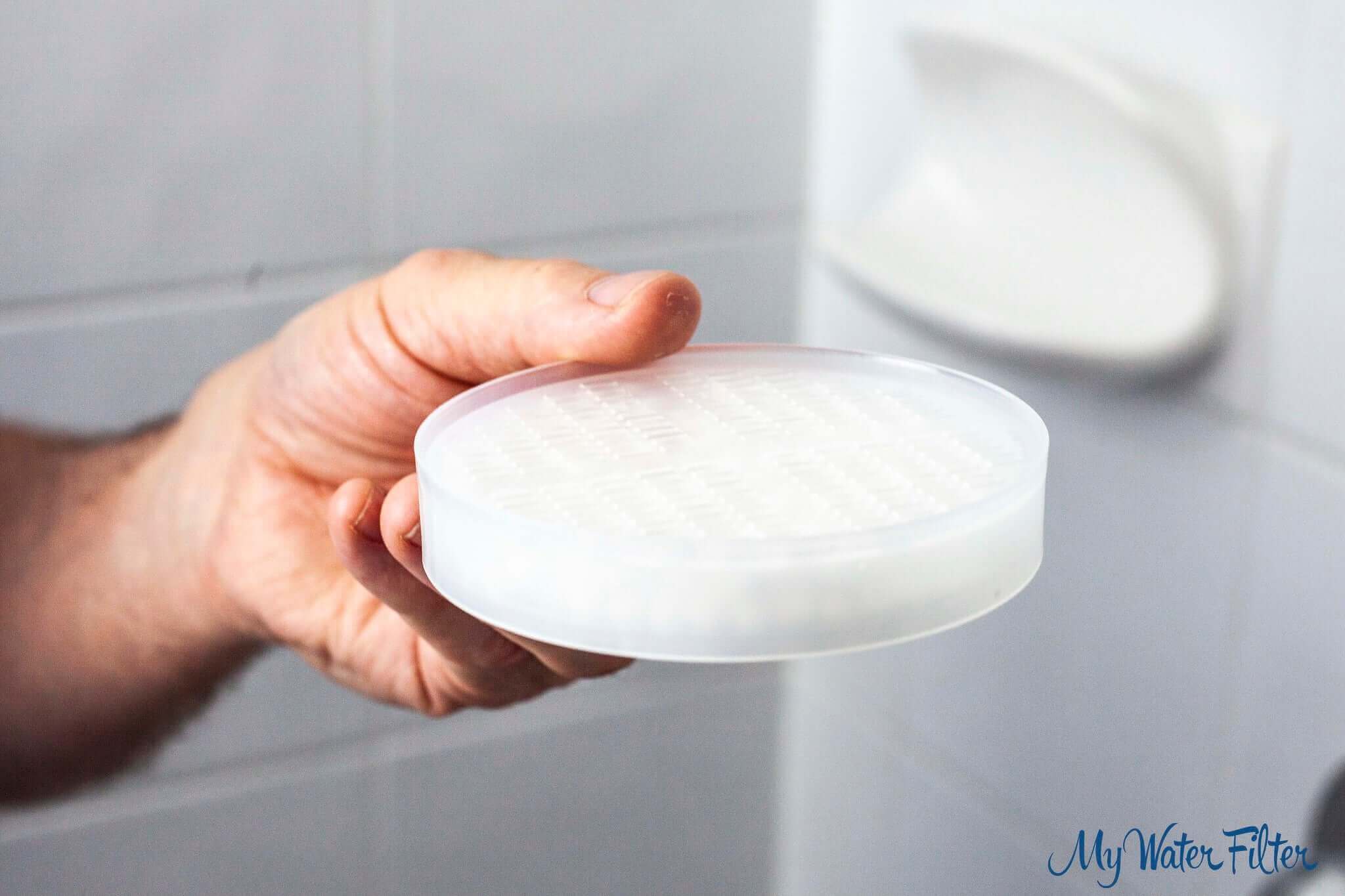 A round shower filter containing Antibacterial Ceramic Balls.