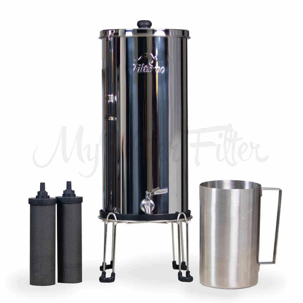 The Filteroo® Superoo 16L Stainless Steel Gravity Water Filter sits on a stand with two black carbon filters and a stainless steel jug.