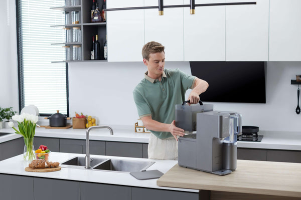 Man refilling coffee machine with Philips Aquaporin Reverse Osmosis Water Station (model ADD6921DG/79).