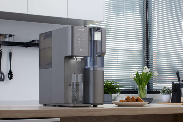Philips Aquaporin Reverse Osmosis Water Station in kitchen with brownies nearby.
