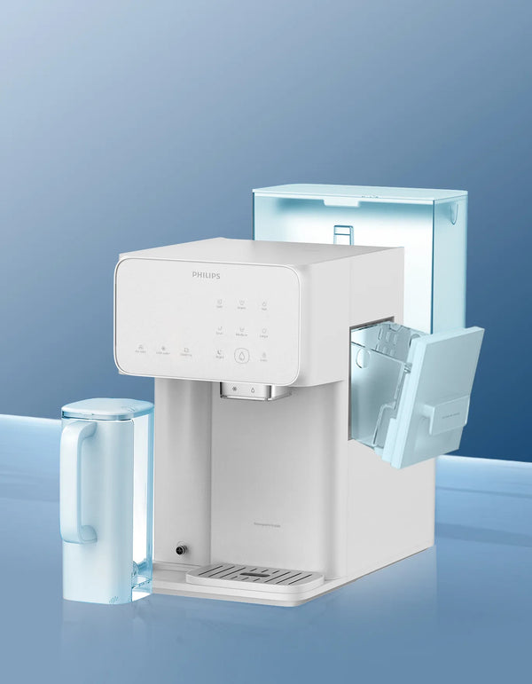 White Philips water station with its ice tank door open, beside a light blue water jug on a blue gradient background.