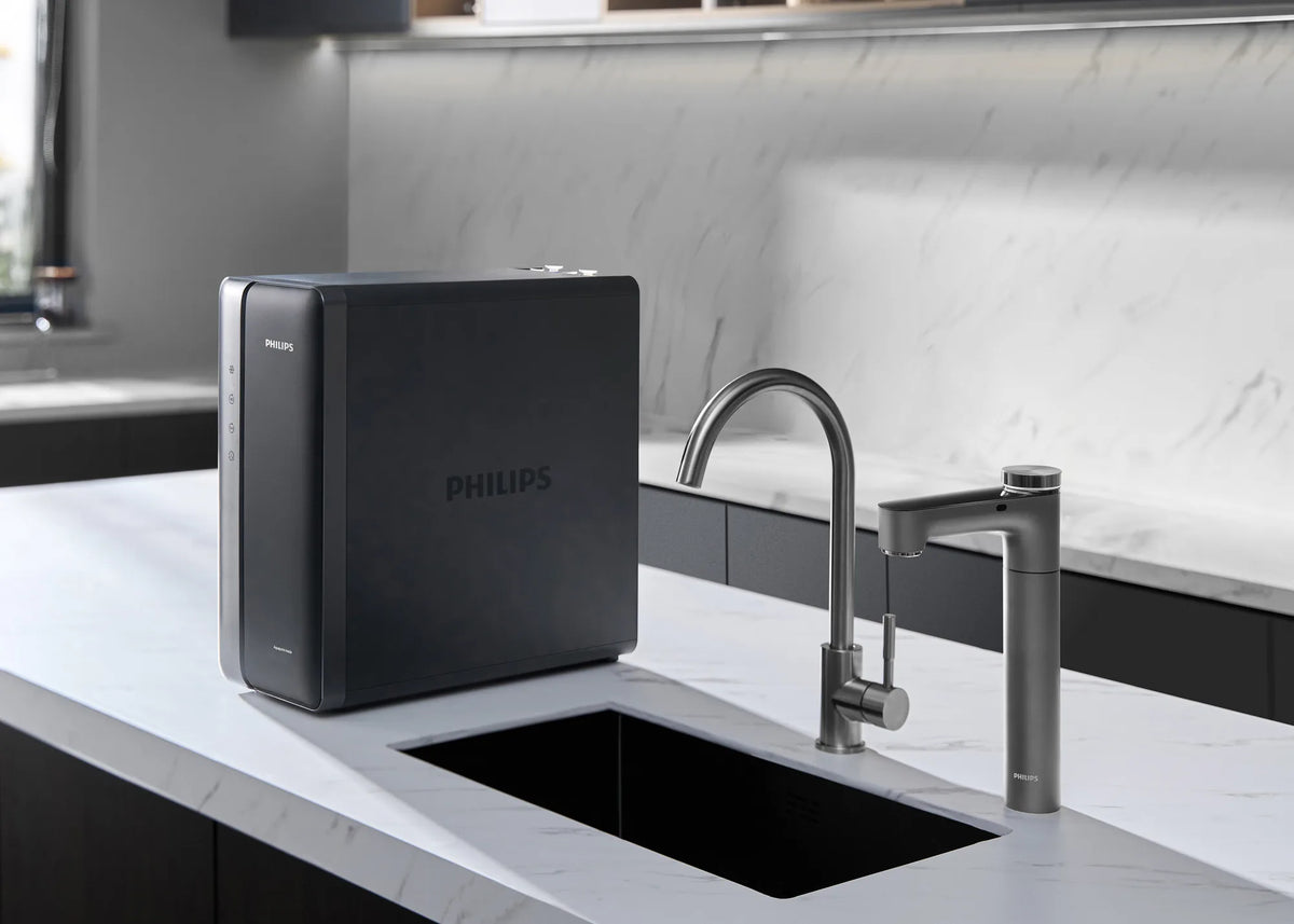 Philips under-sink RO unit on a marble counter beside the sink, with the Philips RO tap and a stainless steel faucet.