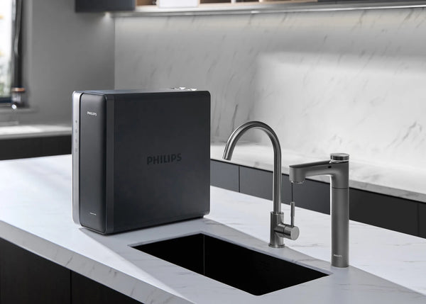 Philips under-sink RO unit on a marble counter beside the sink, with the Philips RO tap and a stainless steel faucet.