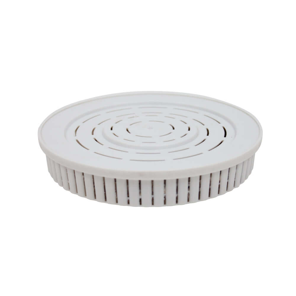 White round air vent cover with a slotted design and ribbed edges of a Drinking Water pH Elevation Mineral Pad for Bench Top Gravity Water Filters.